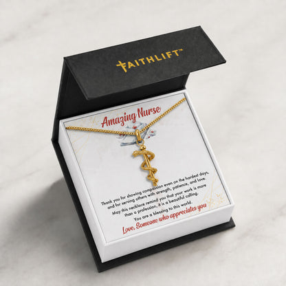 A FaithLift necklace with Rod of Asclepius Necklace displayed inside an open black gift box with a white insert card that reads 'Amazing Nurse' and a personalized message, set on a light marble surface.